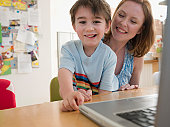 Mother and Son at Table With Laptop
